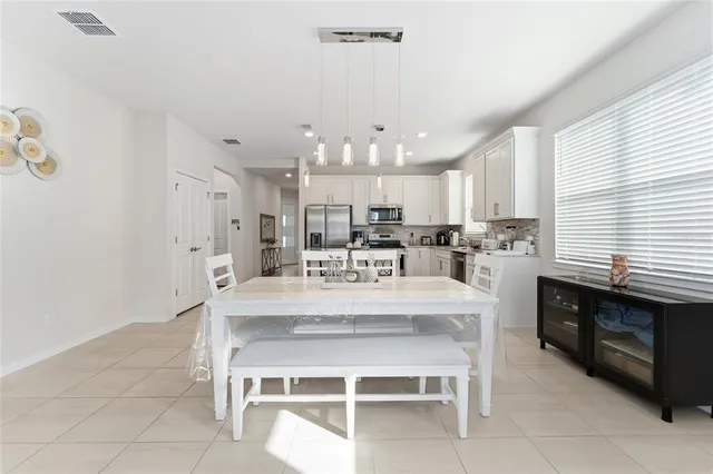 a large white kitchen with a stove a table and chairs