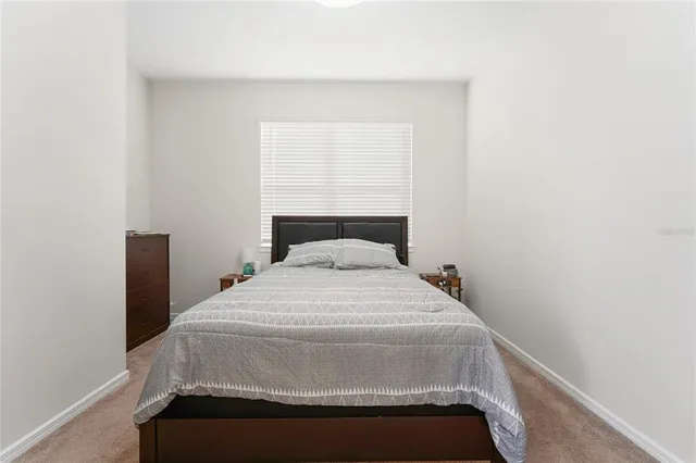 a bed sitting in a bedroom next to a window