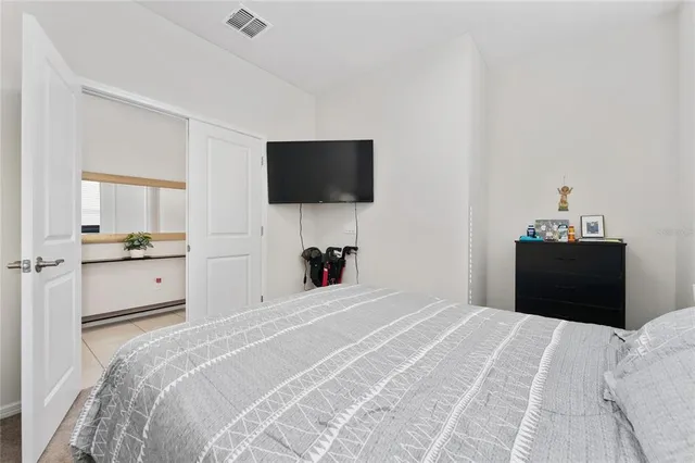 a bedroom with a bed and a flat screen tv