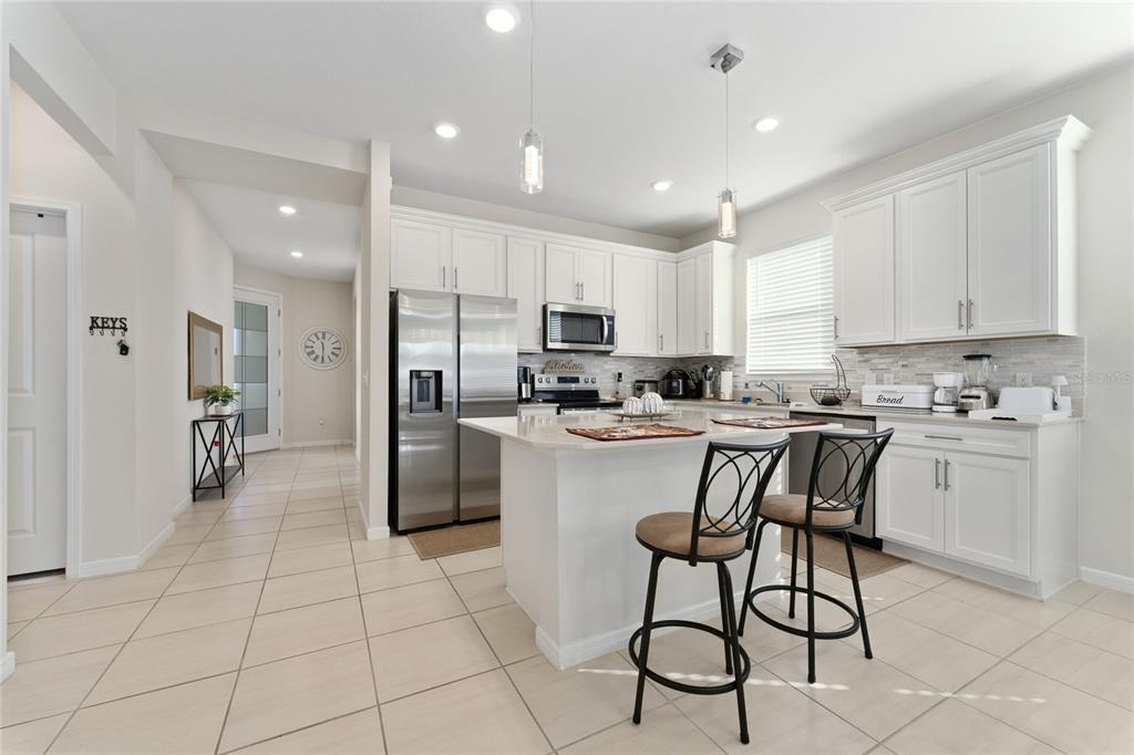1880 Spring Shower Circle Kissimmee, FL 34744 - Photo 10 of 43 a kitchen with stainless steel appliances granite countertop a refrigerator and a stove top oven