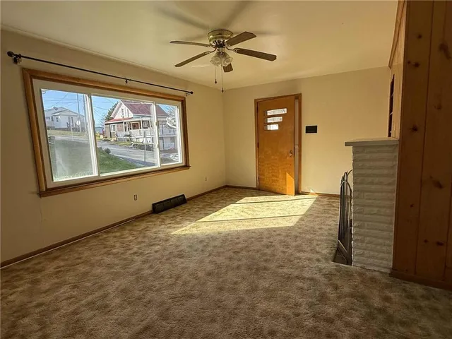 an empty room with a window and a ceiling fan