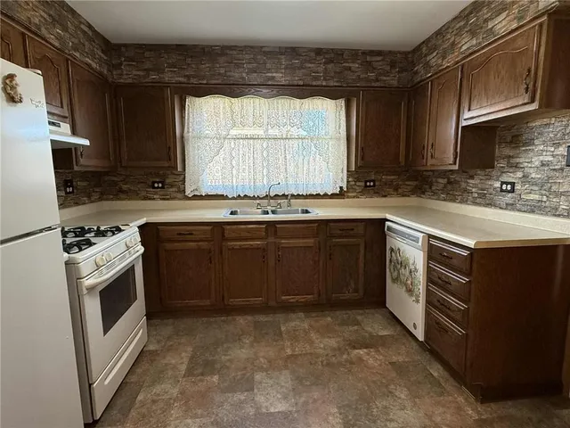 a kitchen with stainless steel appliances a refrigerator sink and cabinets