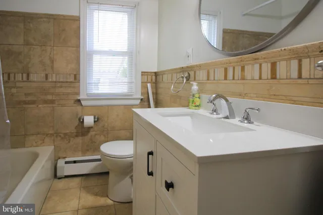 a bathroom with a sink a toilet and a mirror