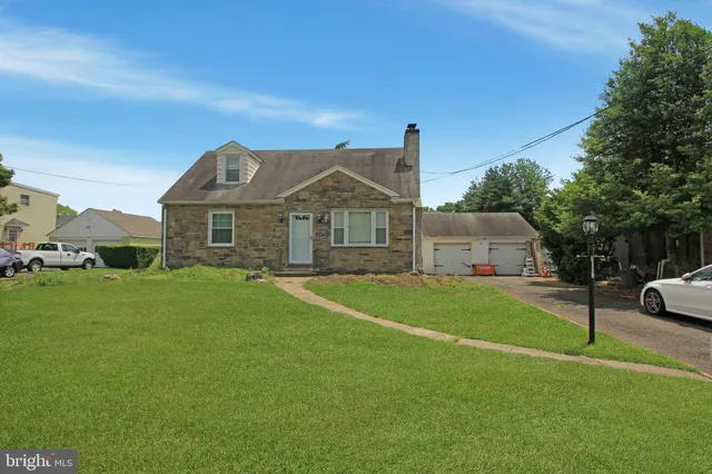 a front view of a house with a yard and trees