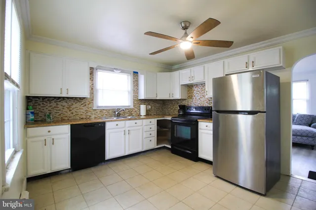 a kitchen with granite countertop stainless steel appliances a refrigerator a sink a stove a microwave and cabinets