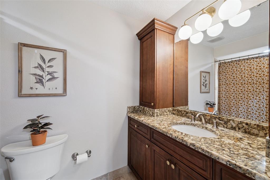 2609 Summerfield Road Winter Park, FL 32792 - Photo 30 of 40 a bathroom with a granite countertop sink mirror vanity and toilet