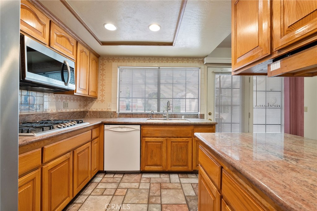 5385 Strasbourg Avenue Irvine, CA 92604 - Photo 20 of 59 a kitchen with stainless steel appliances granite countertop a stove a sink and a microwave