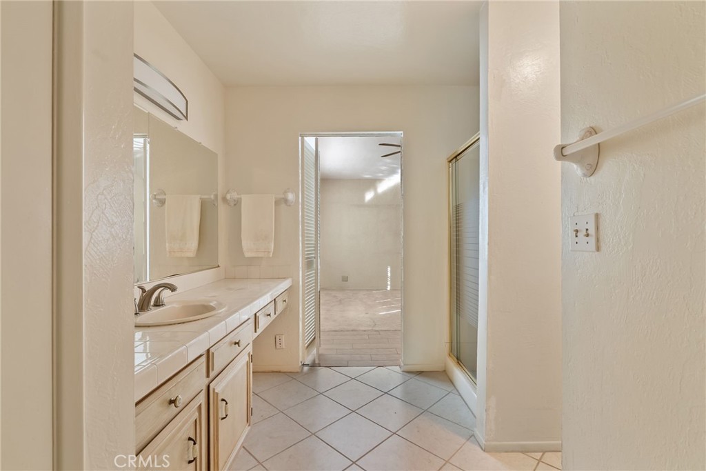 5385 Strasbourg Avenue Irvine, CA 92604 - Photo 41 of 59 a spacious bathroom with a granite countertop sink a mirror and a shower