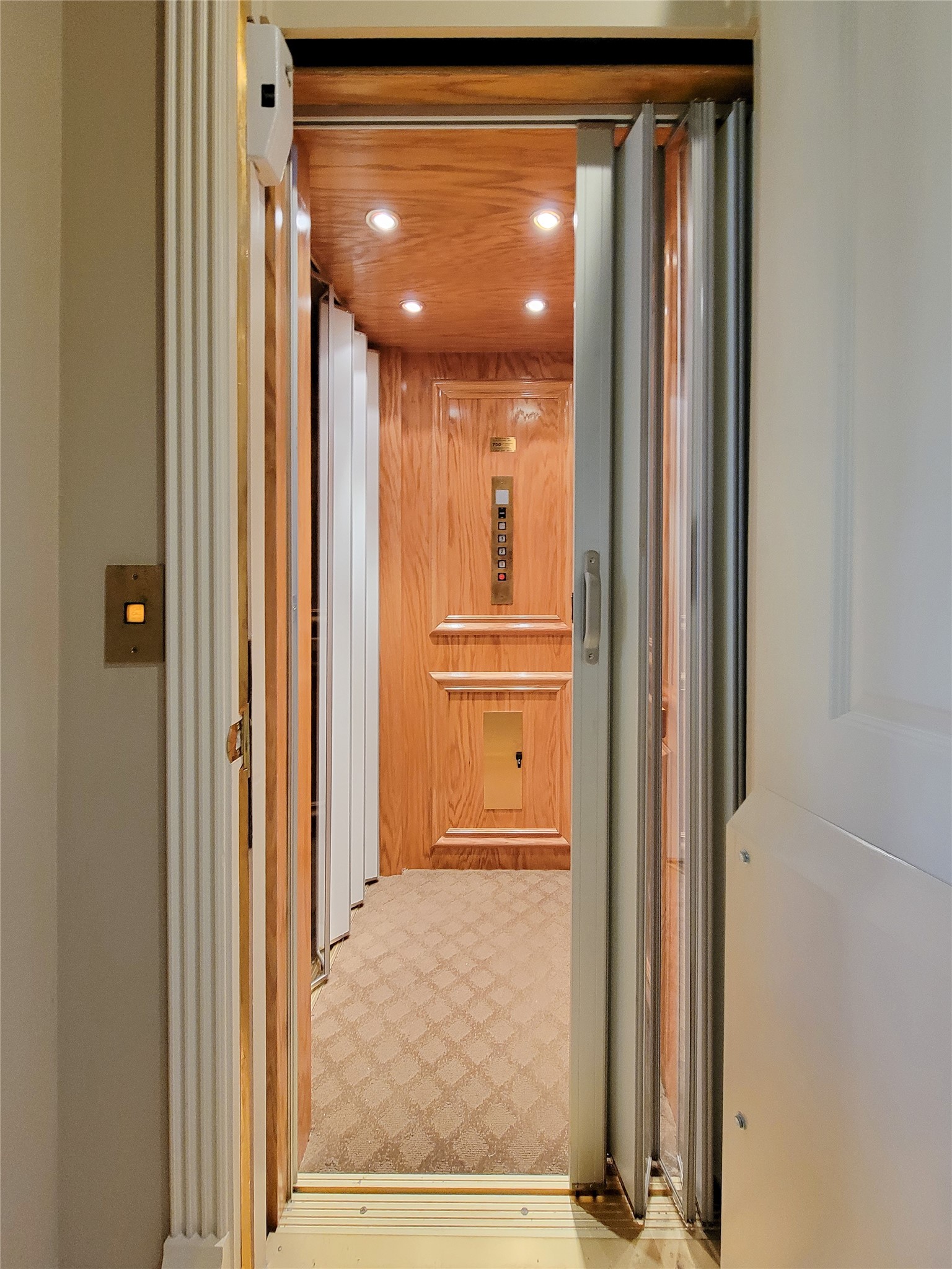 1118 Colonial Street Bellaire, TX 77401 - Photo 15 of 50 Home elevator with wood paneling, carpeted flooring, and recessed lighting, offering a touch of luxury and convenience for multi-level living. Elevator accessible to all three floors.