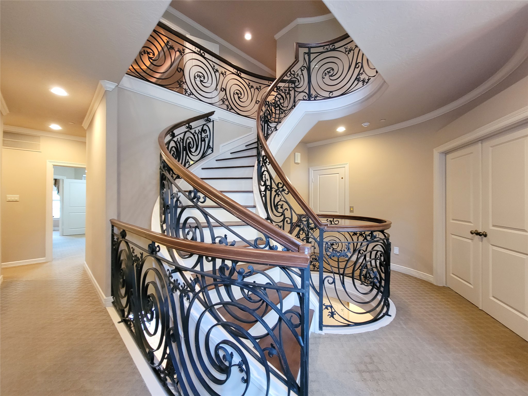 1118 Colonial Street Bellaire, TX 77401 - Photo 16 of 50 Elegant curved staircase with ornate wrought iron railings and wooden handrails. Now for the second-floor tour!