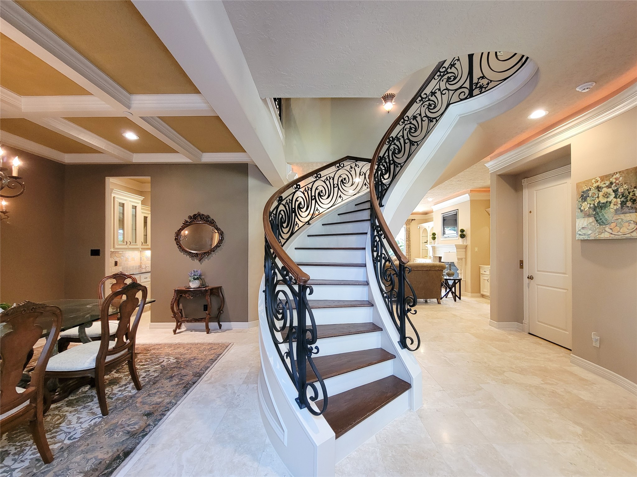 1118 Colonial Street Bellaire, TX 77401 - Photo 2 of 50 Sweeping, circular staircase with gorgeous, decorative, wrought iron rails and wood stairs, travertine flooring, extensive millwork and two-story entryway.