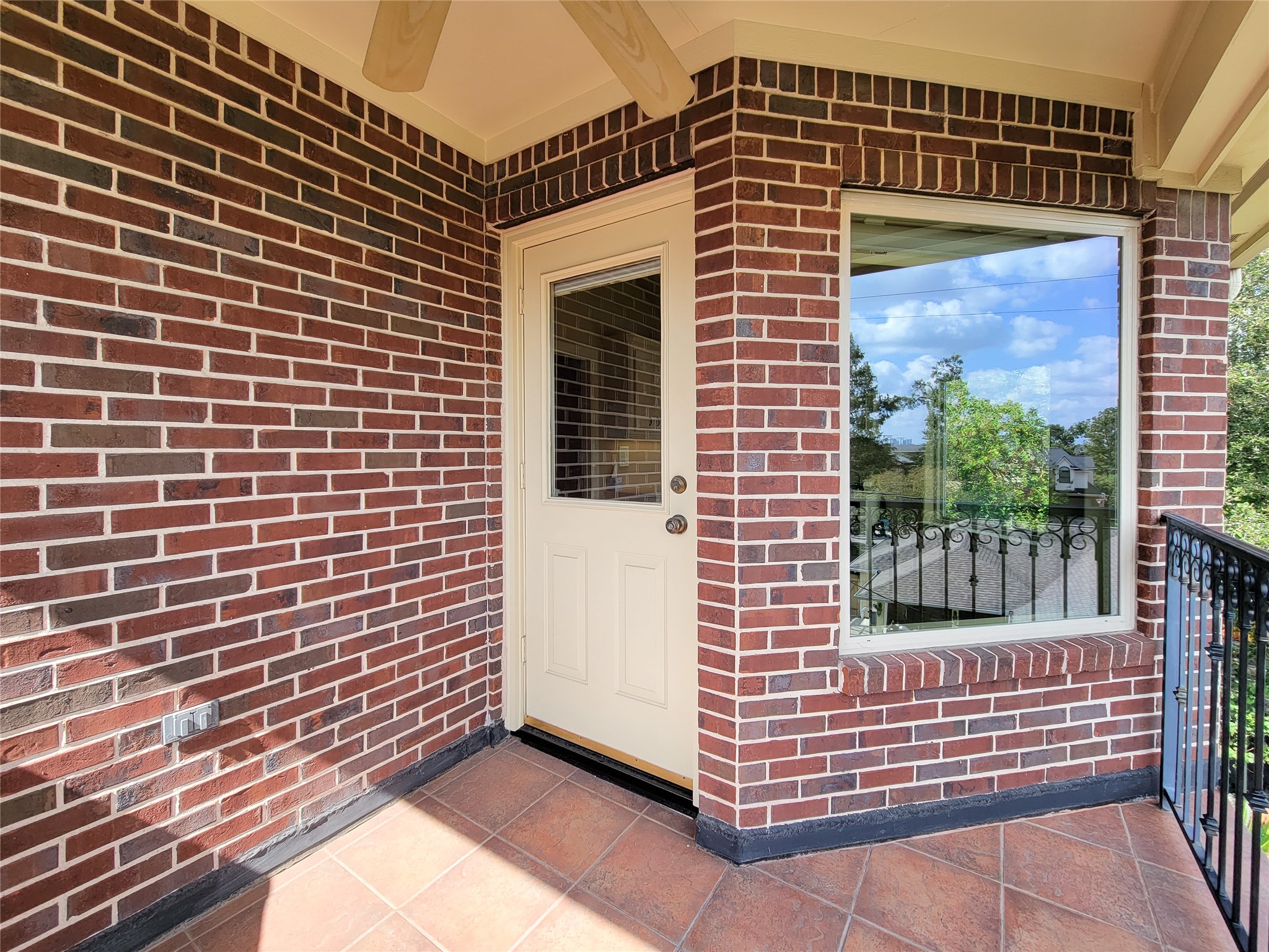 1118 Colonial Street Bellaire, TX 77401 - Photo 35 of 50 This photo shows a cozy brick patio off the fifth bedroom with view of the pool and backyard. This space features tiled flooring and a decorative railing, perfect for enjoying outdoor moments.