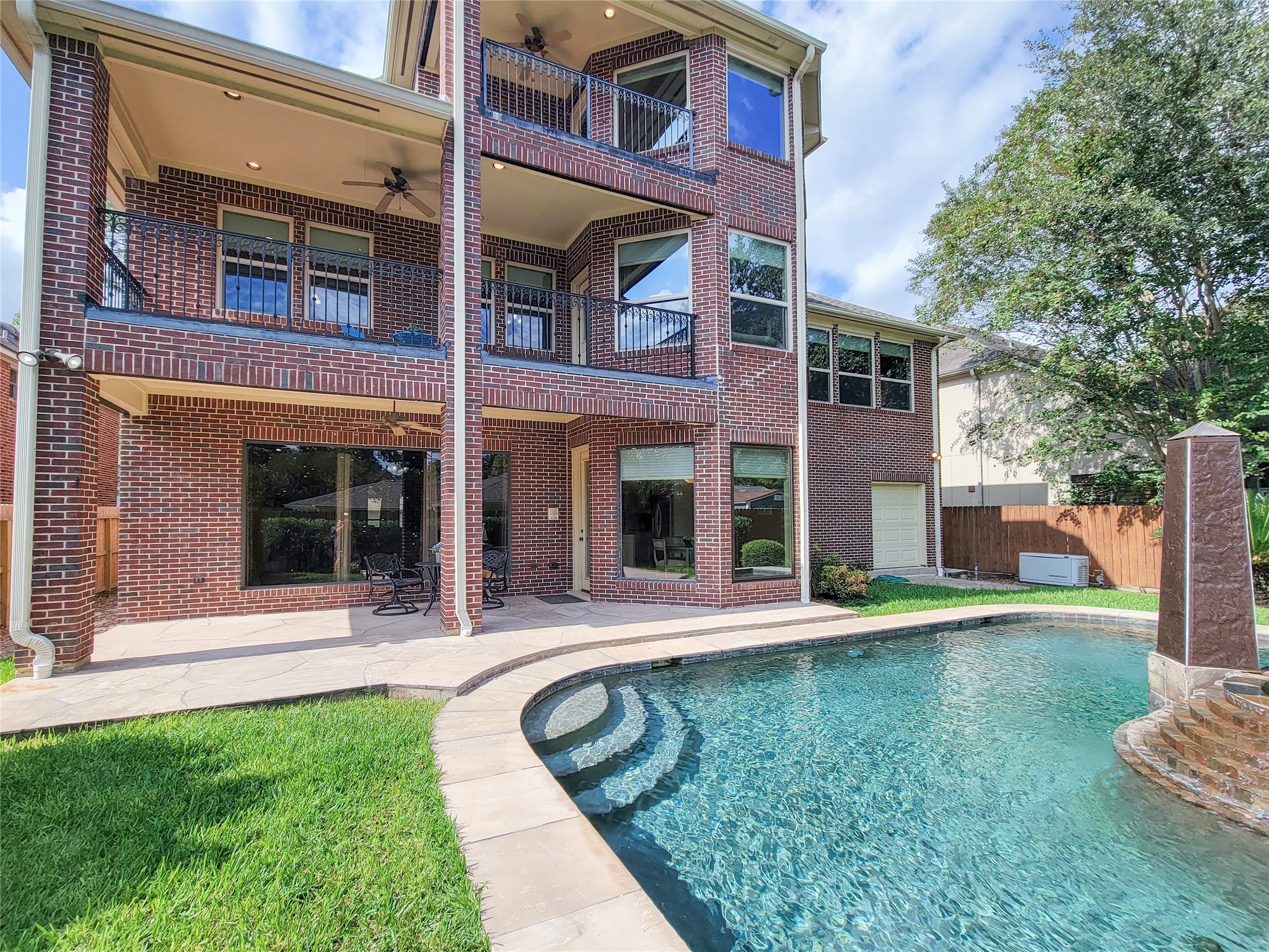 1118 Colonial Street Bellaire, TX 77401 - Photo 39 of 50 This elegant brick home features a spacious backyard with a crystal-clear swimming pool and a covered patio.. The upper balconies offer additional outdoor space for enjoying the scenic views.