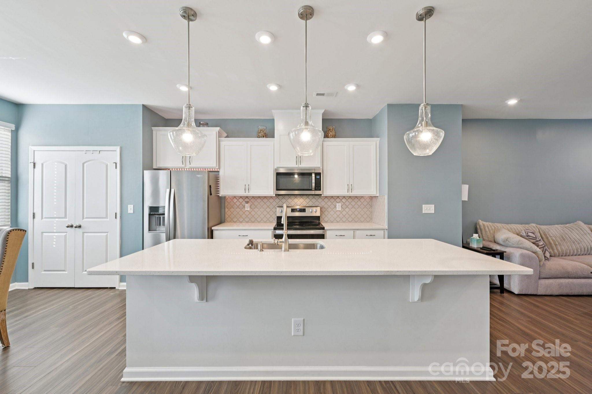 2932 Pirates Place Charlotte, NC 28216 - Photo 14 of 32 a large kitchen with stainless steel appliances kitchen island a large island in the center