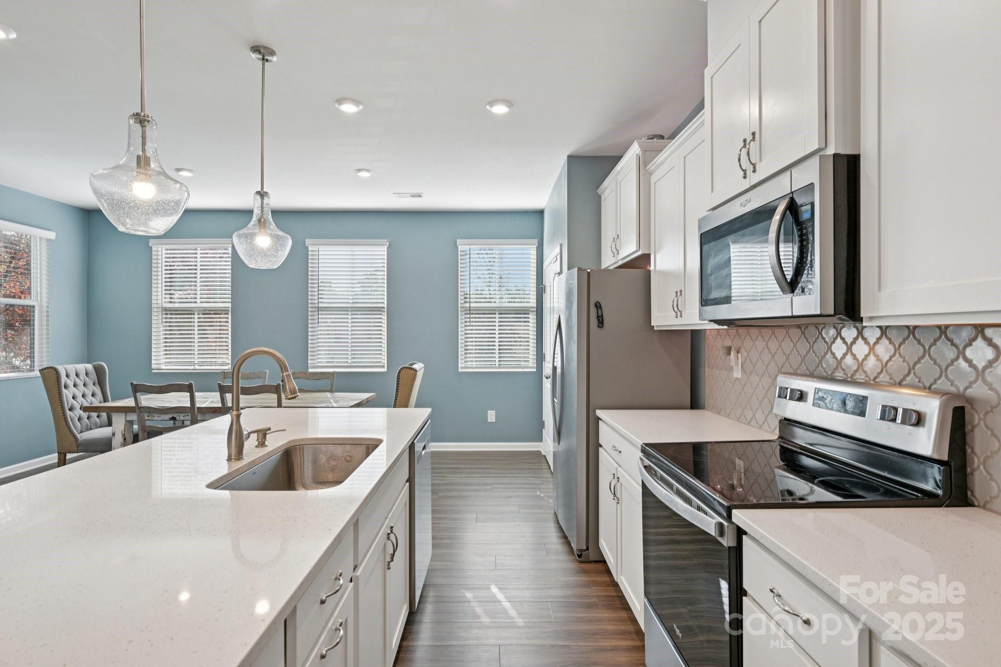 2932 Pirates Place Charlotte, NC 28216 - Photo 15 of 32 a kitchen with stainless steel appliances granite countertop a sink a stove and a wooden floors