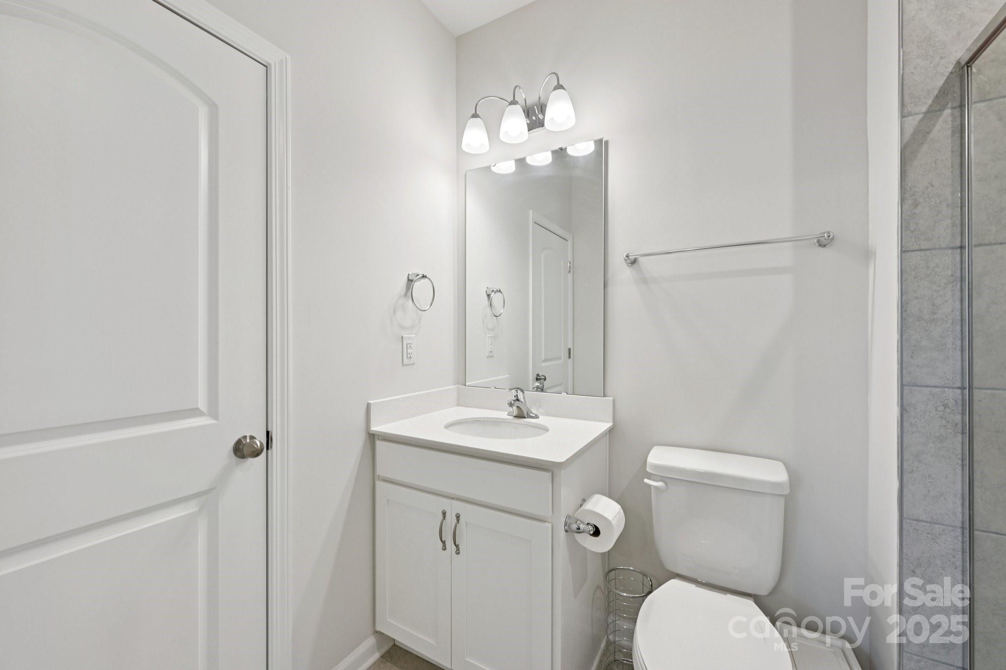 2932 Pirates Place Charlotte, NC 28216 - Photo 19 of 32 a bathroom with a toilet a sink and mirror