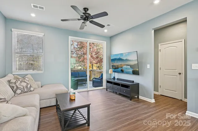 a living room with furniture and a wooden floor