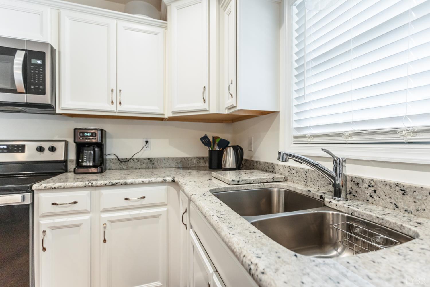 7099 Oakville Road Appomattox, VA 24522 - Photo 11 of 31 a kitchen with granite countertop a sink a stove and cabinets