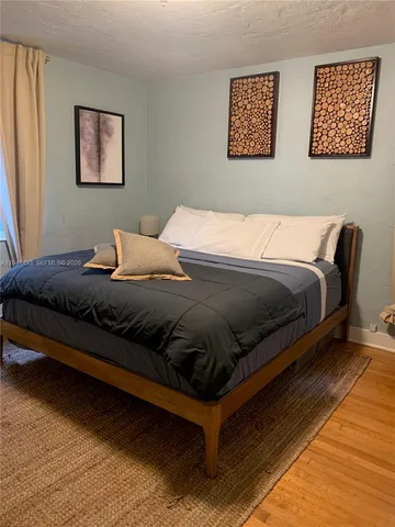 a bedroom with bed and painting on the wall