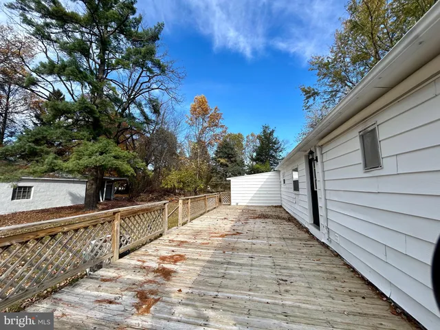 a view of a white house with a yard and large trees