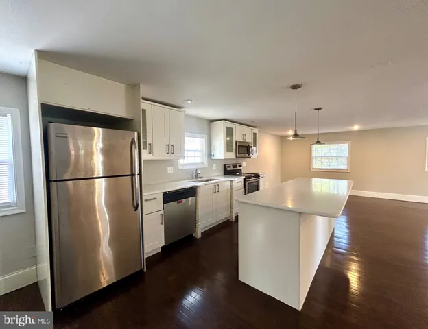 a kitchen with stainless steel appliances granite countertop a refrigerator microwave and sink