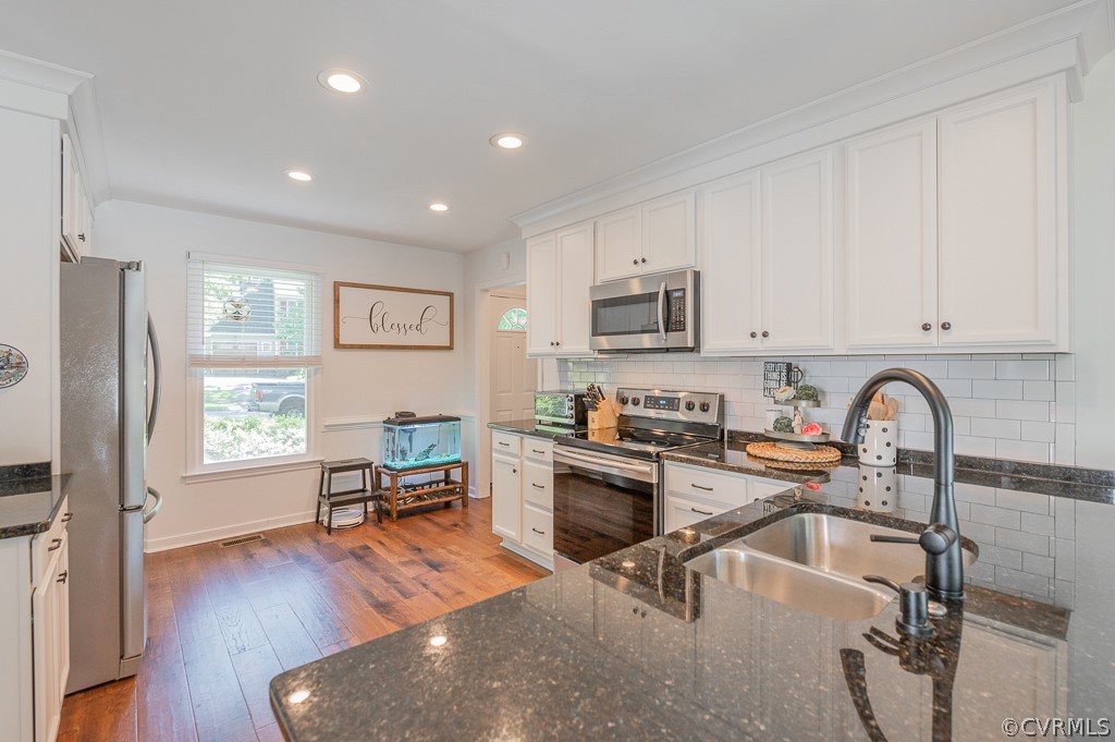 5906 Acorn Ridge Court Midlothian, VA 23112 - Photo 6 of 48 a kitchen with stainless steel appliances granite countertop a refrigerator a sink dishwasher a stove top oven a dining table and chairs with wooden floor