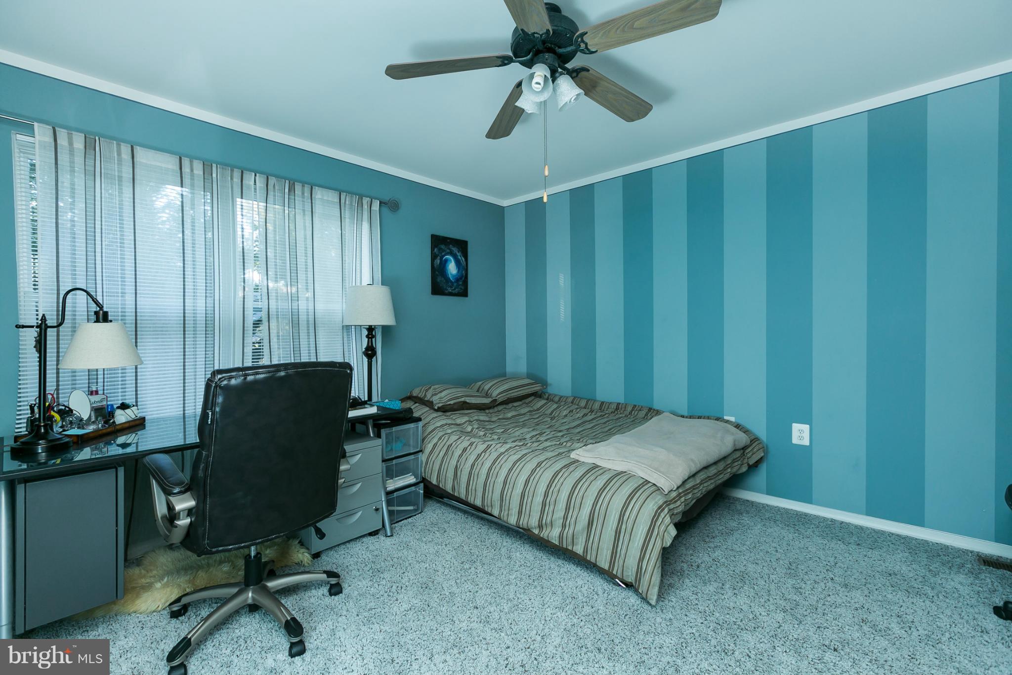 6824 Old Pimlico Road Baltimore, MD 21209 - Photo 14 of 20 a bedroom with a bed and a chandelier