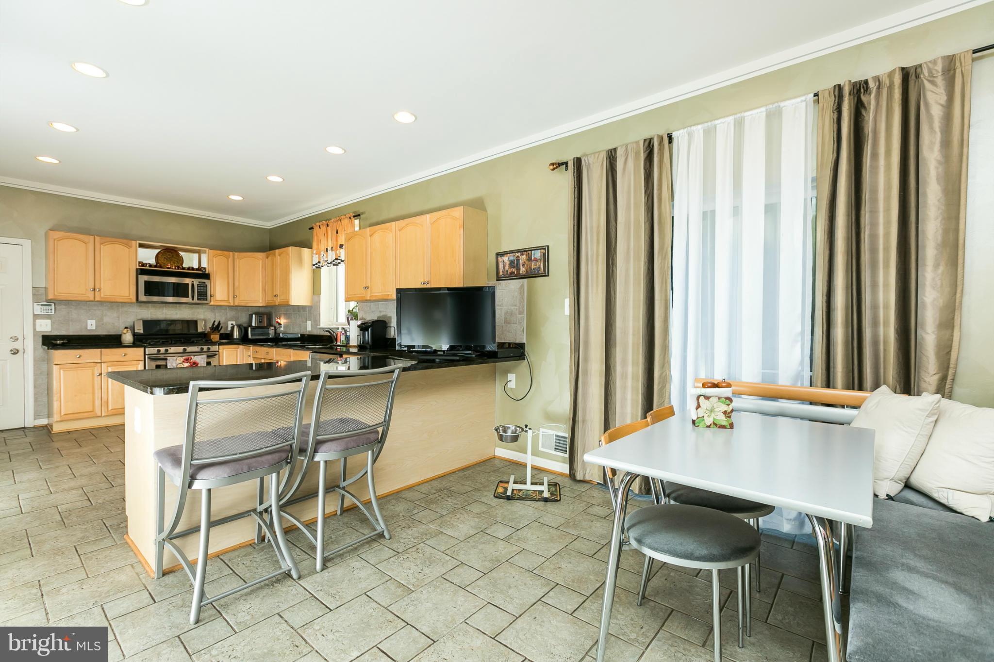 6824 Old Pimlico Road Baltimore, MD 21209 - Photo 7 of 20 a kitchen with stainless steel appliances kitchen island granite countertop a table and chairs