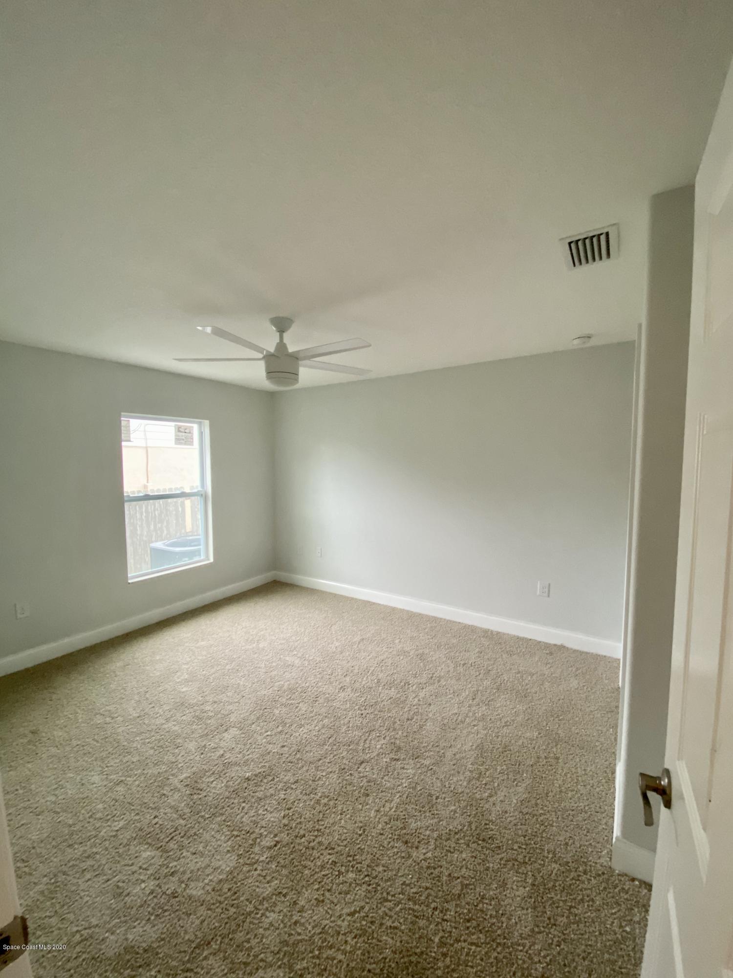 6444 Hudson Road Cocoa, FL 32927 - Photo 19 of 21 an empty room with windows and ceiling fan