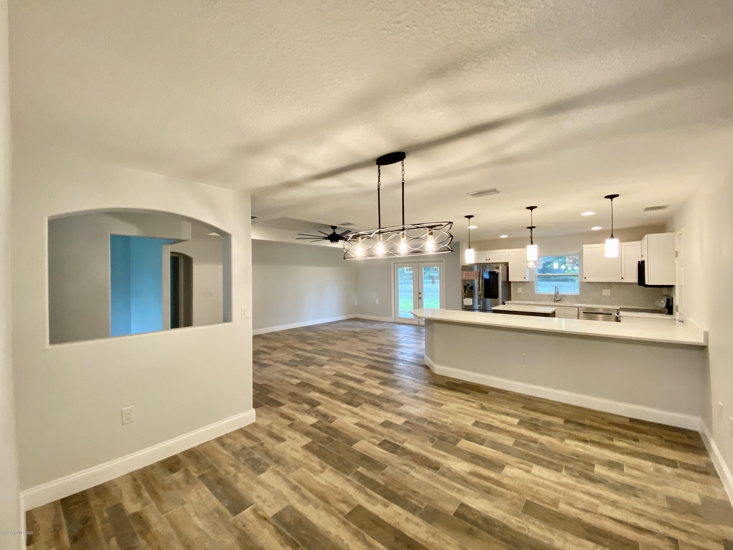 6444 Hudson Road Cocoa, FL 32927 - Photo 5 of 21 a open kitchen with kitchen island a refrigerator stove a sink and a white countertops with wooden floor