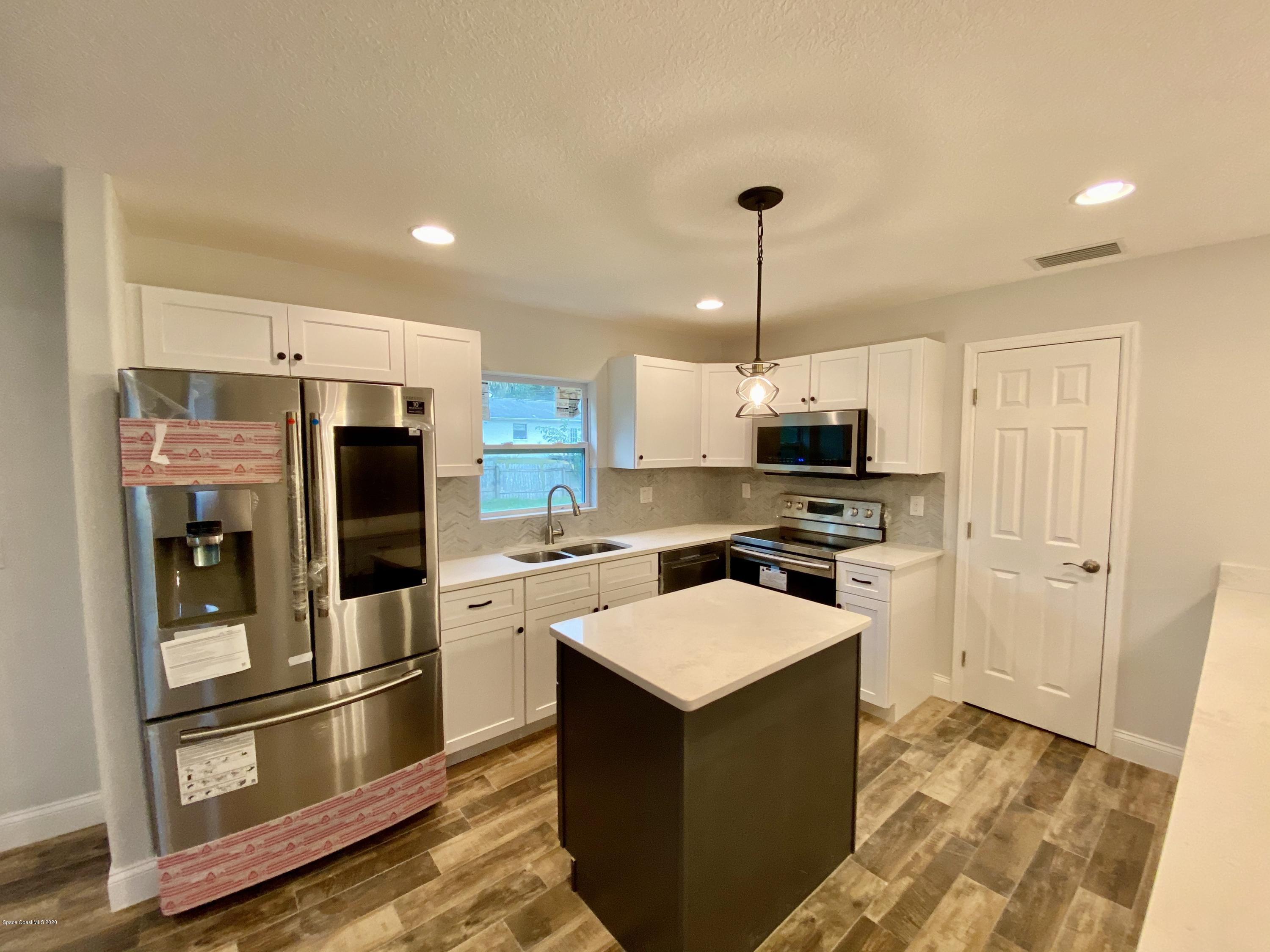 6444 Hudson Road Cocoa, FL 32927 - Photo 9 of 21 a kitchen with stainless steel appliances a refrigerator a stove a sink and a oven