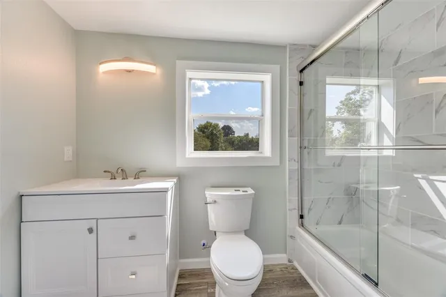 a bathroom with a sink a toilet and shower