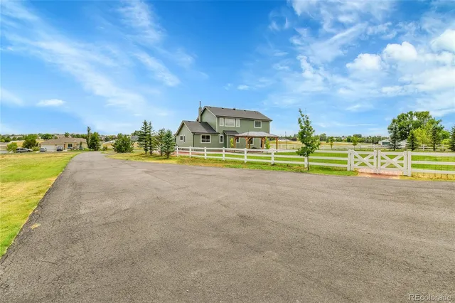 a view of an house with backyard and road