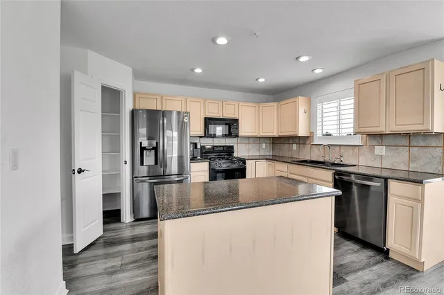 a kitchen with a refrigerator a sink a stove a microwave and cabinets