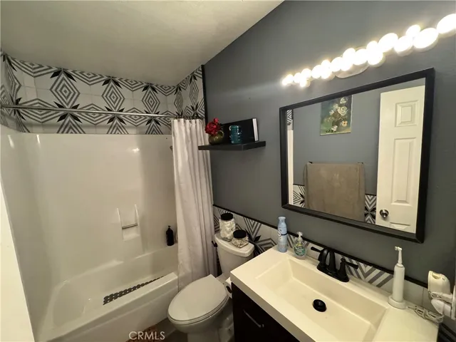 a bathroom with a sink mirror toilet and shower
