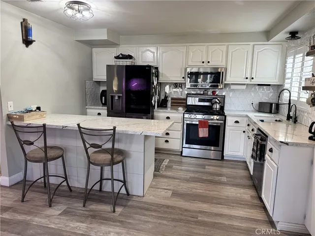 a kitchen with stainless steel appliances a stove a sink cabinets and a refrigerator
