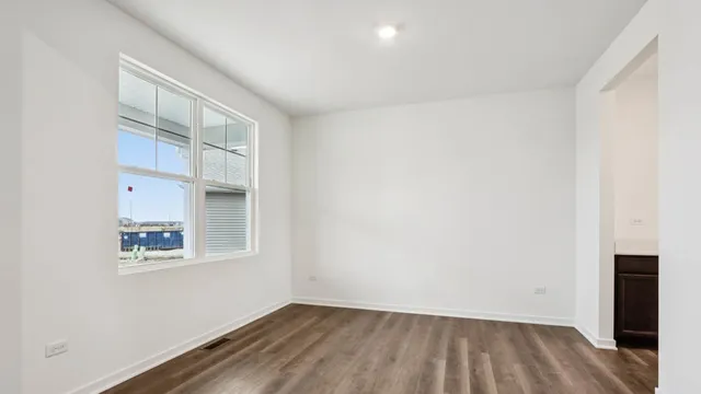 an empty room with wooden floor and closet