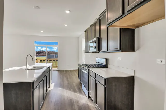 a kitchen with stainless steel appliances granite countertop a sink stove and cabinets