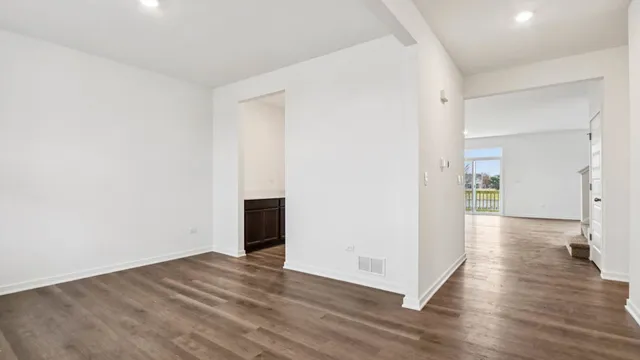 a view of a big room with wooden floor and windows