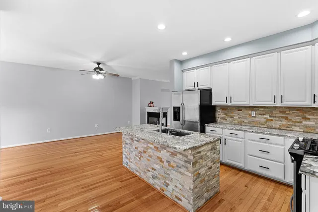 a kitchen with kitchen island granite countertop a stove sink and microwave