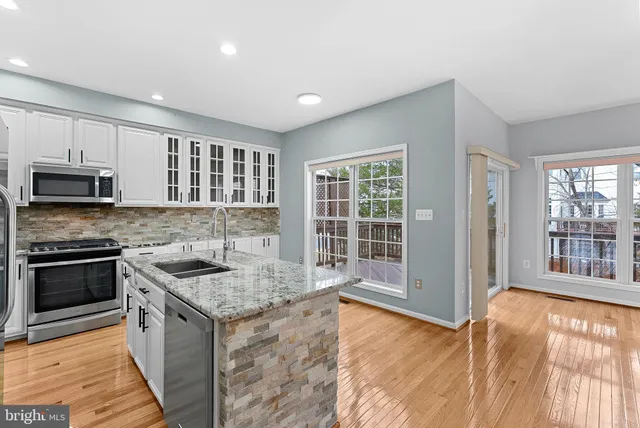a kitchen with a sink a counter top a stove and a window