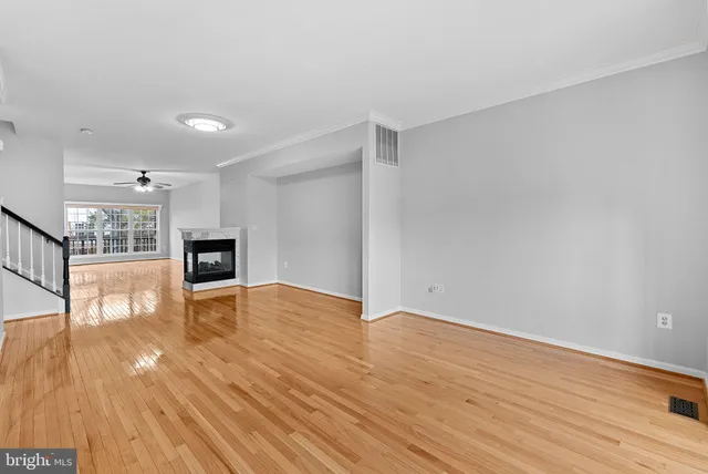 a view of empty room with wooden floor and fireplace