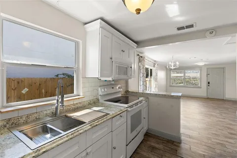 a kitchen that has a sink and a stove in it