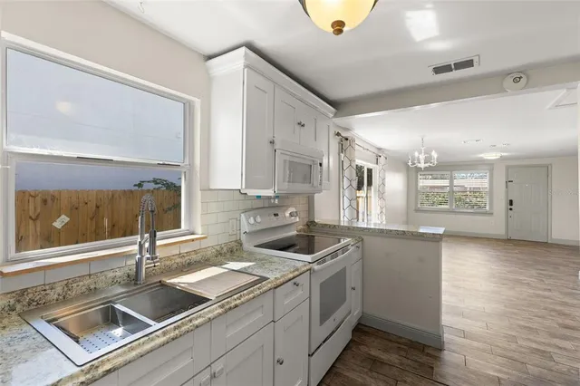 a kitchen that has a sink and a stove in it