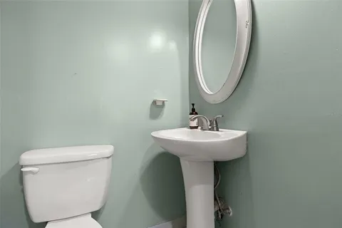 a bathroom with a toilet sink and mirror