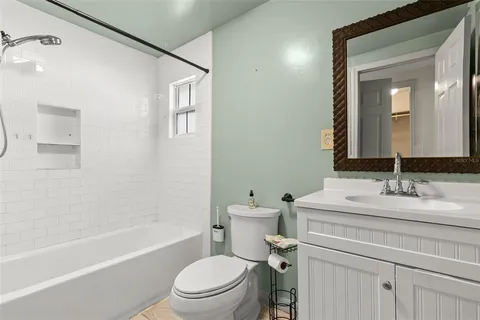 a bathroom with a sink toilet vanity tub and shower