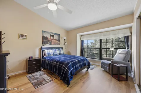 a living room with a bed couches and a flat tv screen