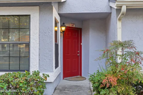 front view of a brick house with a flower plants