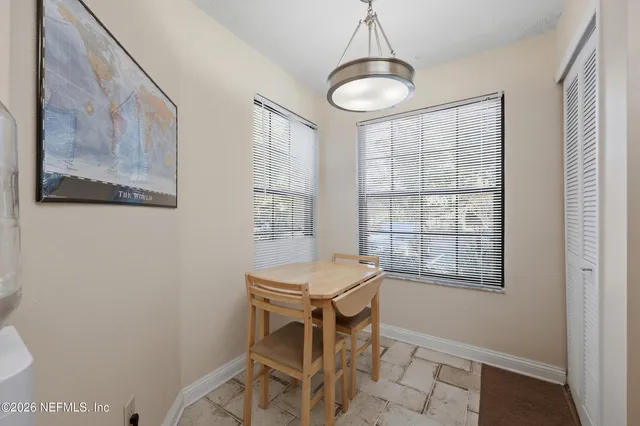 a room with chandelier fan and windows