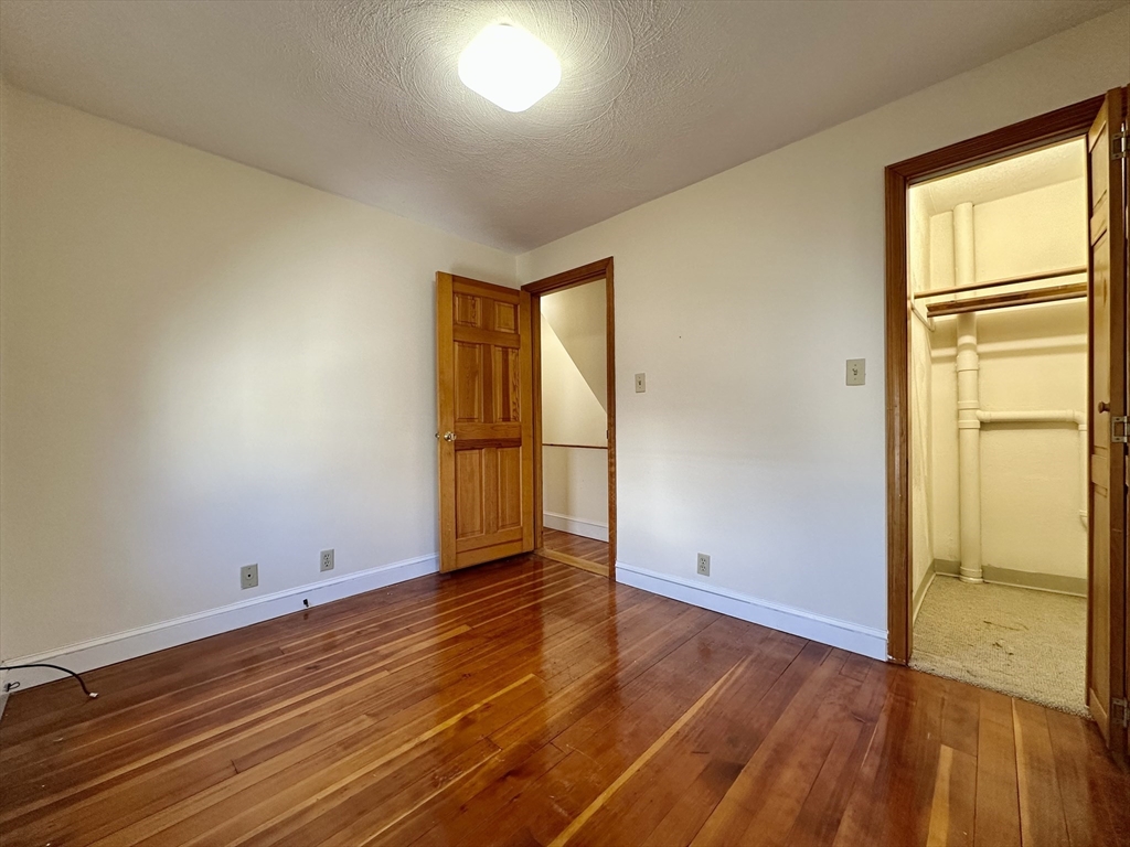 5 Rifle Court, Unit 5 Watertown, MA 02472 - Photo 12 of 14 an empty room with wooden floor and a window